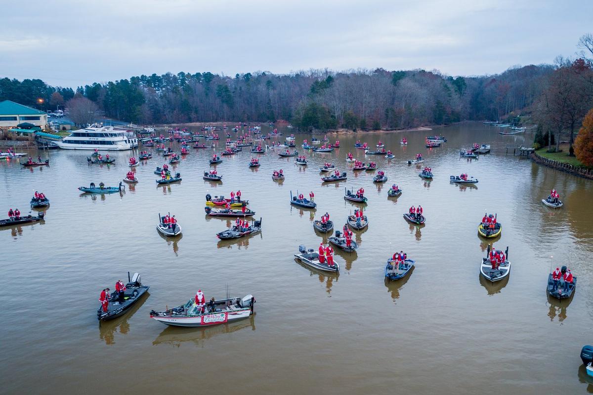 Lake full of boats containing anglers dressed as Santa