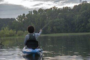 Angler reeling in fish from boat