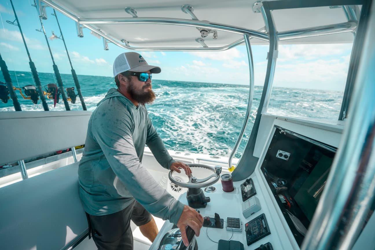 Angler at steering wheel of boat