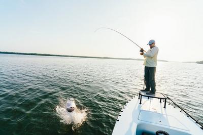 Angler reeling in fish on boat