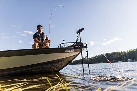 Angler reeling in fish from boat