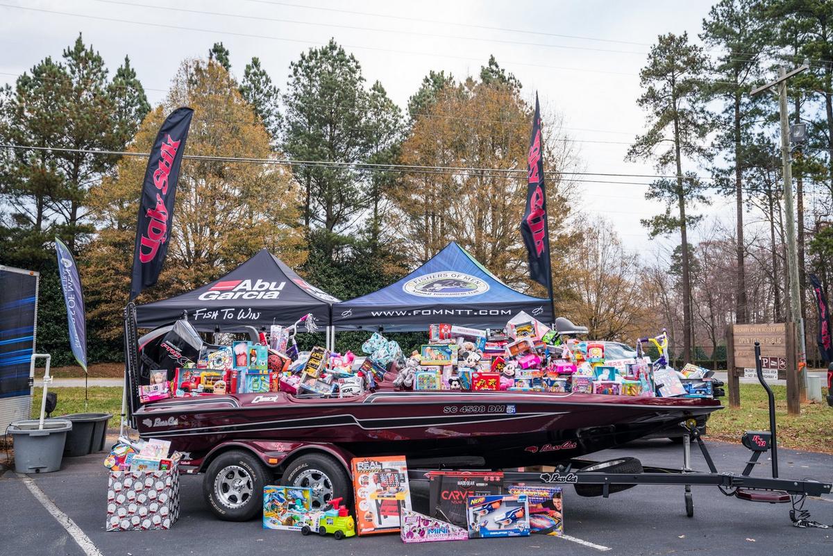 Boat full of gifts for children surrounded by Ugly Stik banners and tents for Abu Garcia and Fishers of Men