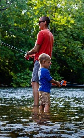 Young girl holding fishing rod and looking toward the sky