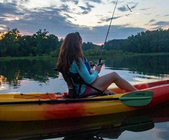 Young girl holding fishing rod and looking toward the sky