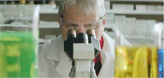 Scientist looking through microscope