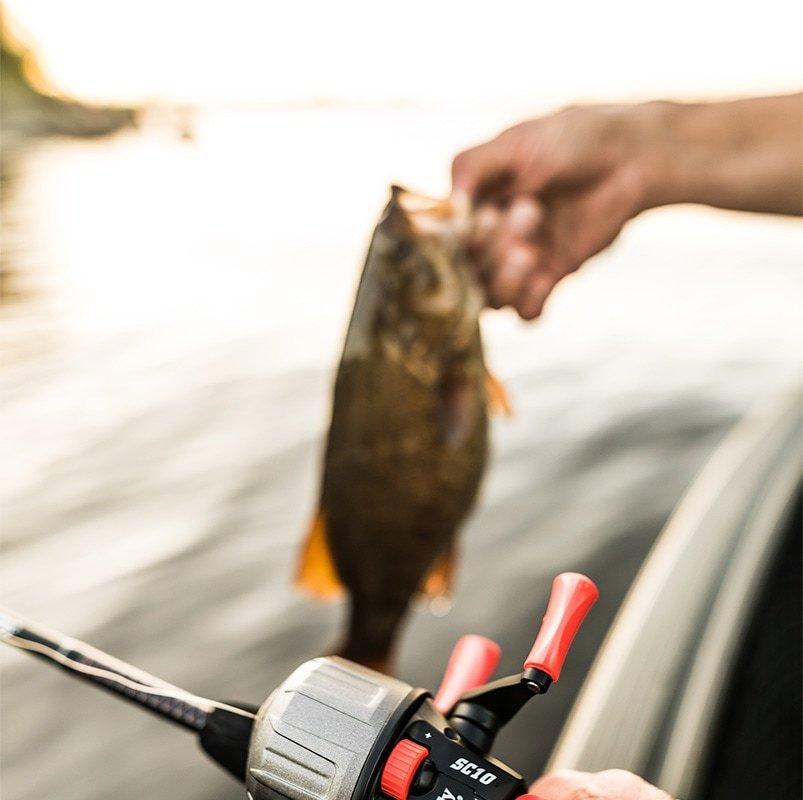 Angler gripping fish with Ugly Tuff reel in hands